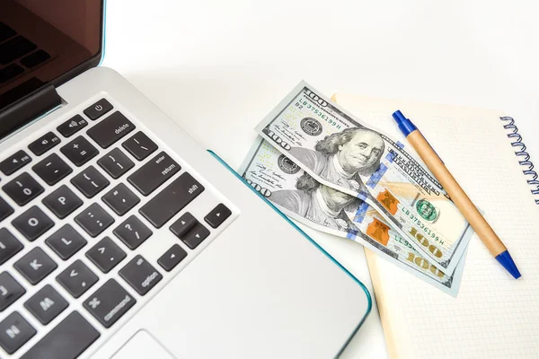 Close-up van laptop en geld op een notitieblok — Stockfoto