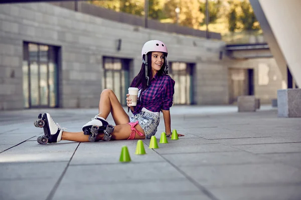 Adolescente patinando sentado na rua e beber café — Fotografia de Stock