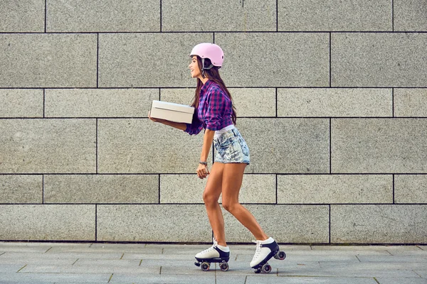 Entrega em patins de rolo por menina bonita no capacete — Fotografia de Stock