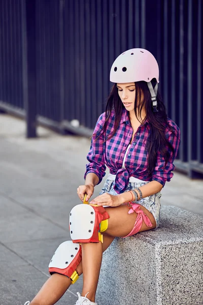 Menina bonita coloca em equipamento de proteção para patins — Fotografia de Stock