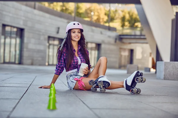 Young woman have a rest after rollerblading and drinking coffee — Stok fotoğraf