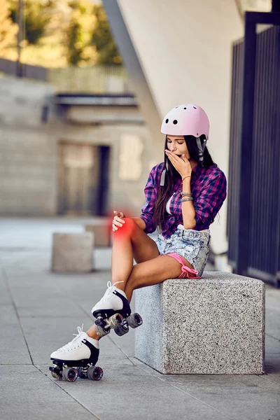 A menina em patins machucou o joelho no parque urbano — Fotografia de Stock