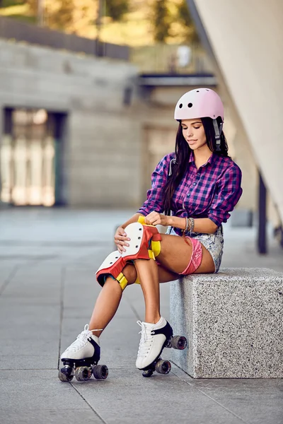 Jovem mulher esportiva e equipamento de proteção de patinação — Fotografia de Stock