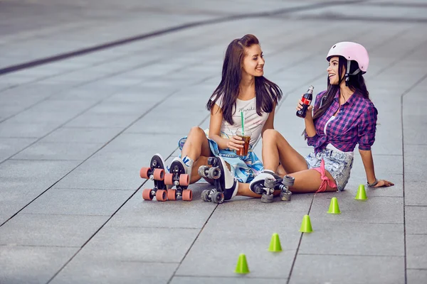 Chicas jóvenes en el parque de skate con patines y limonada — Foto de Stock