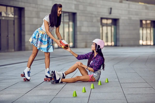 Menina cair e coçar a perna depois de patinar — Fotografia de Stock