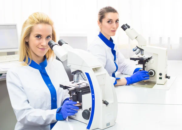 Dos trabajadores médicos que trabajan con microscopio — Foto de Stock