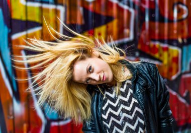 blonde in skate park is playing with her hair
