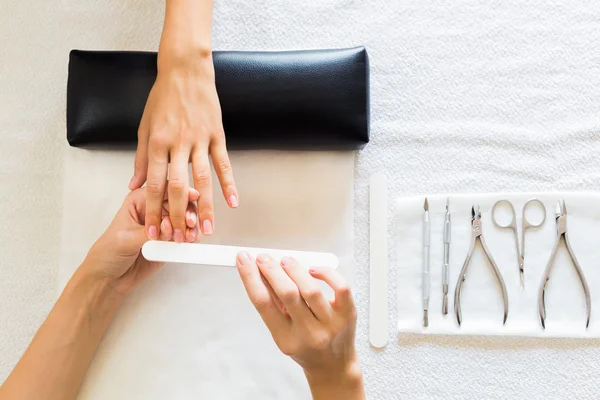 Schoonheidsspecialiste manicure wilt uitvoeren op een dame — Stockfoto