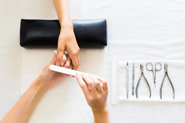 Manikérka podání nehty ženy — Stock fotografie