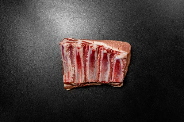 Raw pork ribs on black background