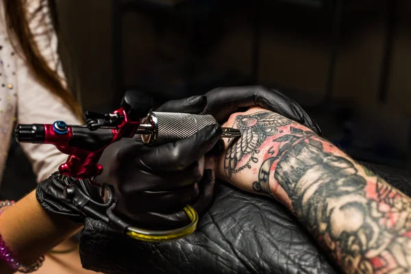 Tattooist showing process of making a tattoo — Stock Photo, Image