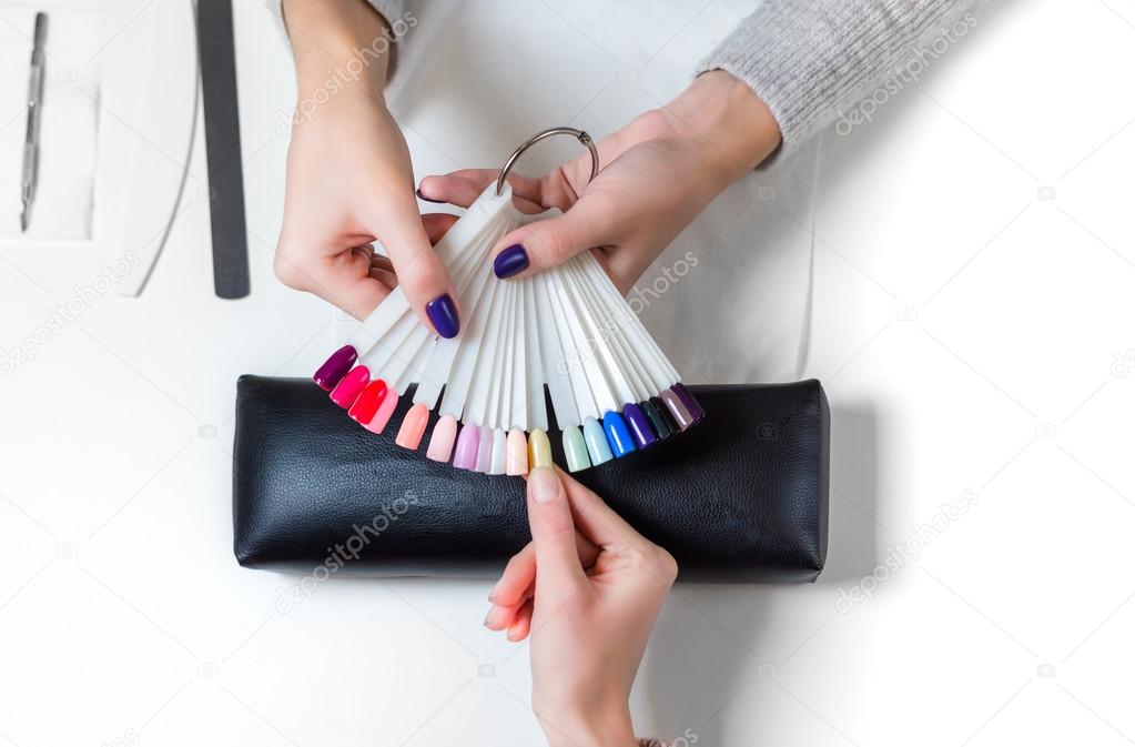 Woman selects yellow color shellac for nail