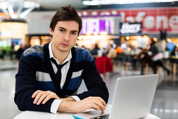 Serious man using portable computer on table