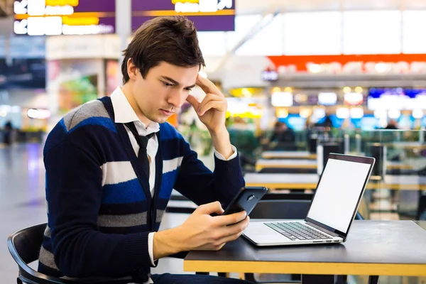 Cheerful handsome guy reads message on phone