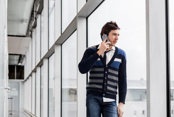 Hombre de negocios urbano hablando de teléfono cerca de una ventana — Foto de Stock