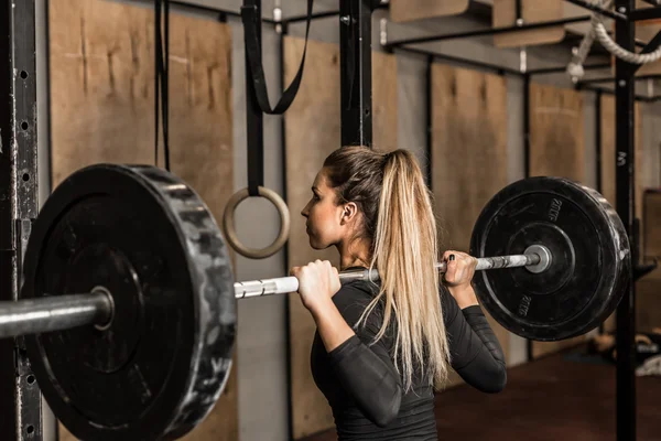 Atlet wanita muda melakukan squat di gym — Stok Foto