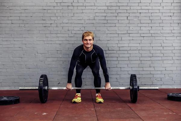 Jovem fazendo exercício de deadlift no ginásio — Fotografia de Stock