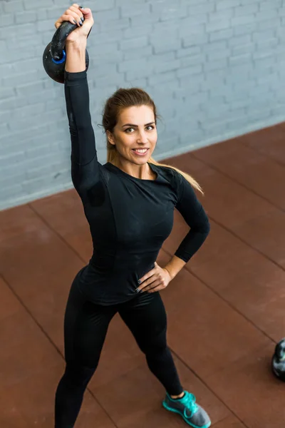 Woman exercising with a kettlebell weight — Stock Photo, Image