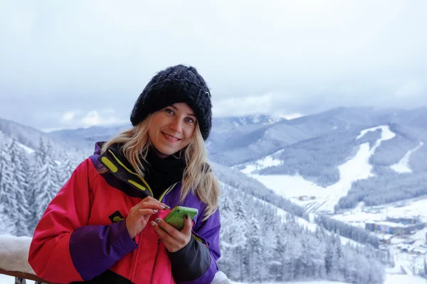 Усміхнена жінка пише повідомлення в горах — стокове фото