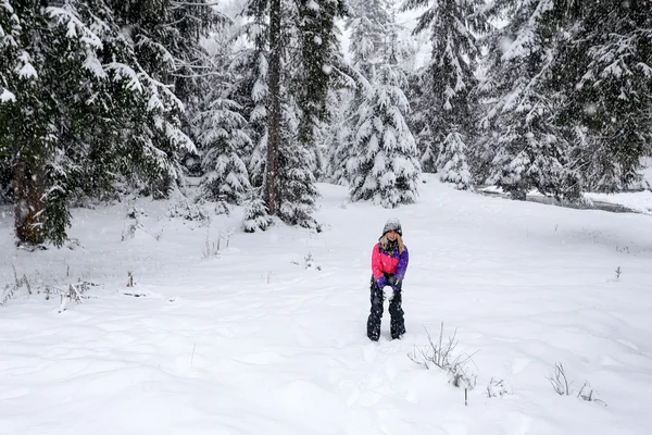 Fille jouer boules de neige en hiver couvert de neige forêt — Photo