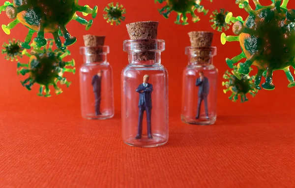 Miniature businessmen practicing social distancing by quarantining in glass bottles to slow the spread of the deadly coronavirus metaphor