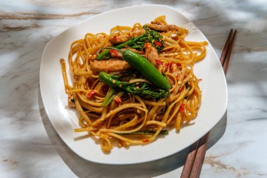 Pad kee mao otherwise known as drunken noodles is a spicy Thai stir-fried noodle dish with thinly sliced chicken thighs and chinese broccoli clipart