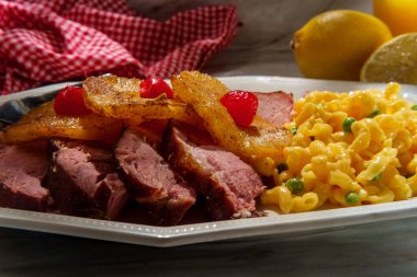 Kızarmış ballı narenciye jambonlu akşam yemeği dilimlenmiş ananas halkaları ve yanında yeşil bezelyeli makarna ve peynirli maraska kirazı.