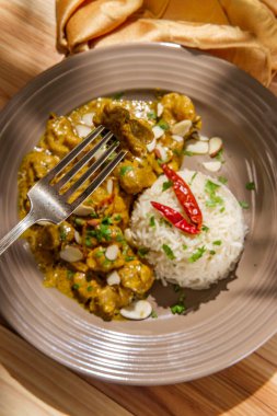 Hint usulü körili tavuk, basmati pilavı ve bademle birlikte.