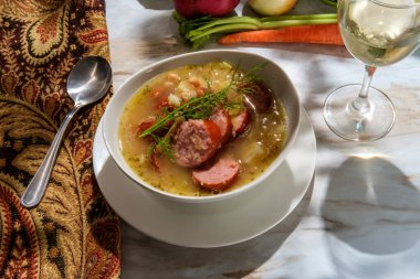 Alman kielbasa Ekim Festivali güveci lahana patatesleri ve bir bardak beyaz şarap.