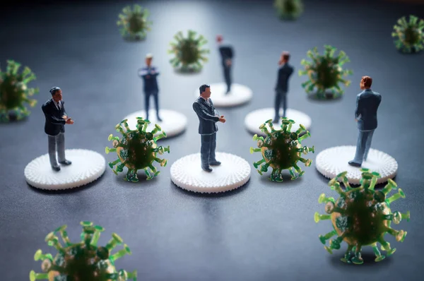 Miniature businessmen practicing social distancing to slow the spread of the deadly coronavirus