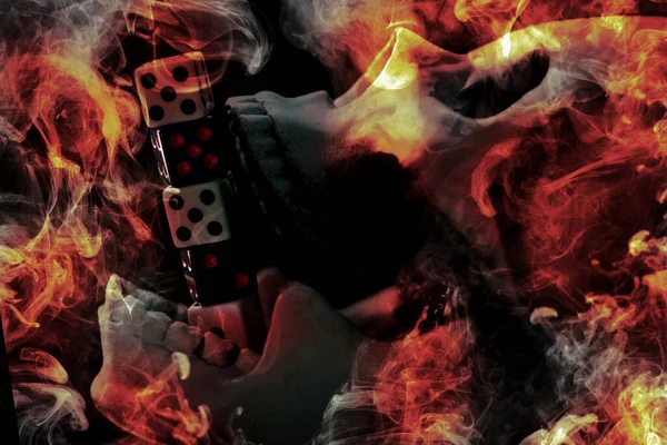 Skull burning in hell with gambling dice addiction concept
