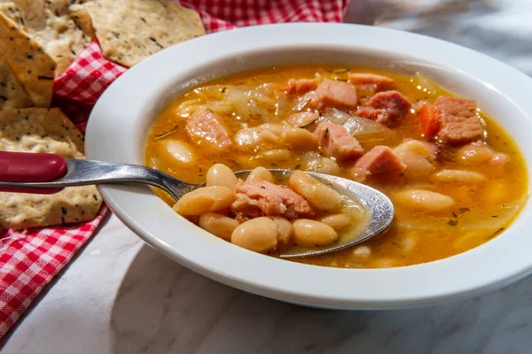 Simple slow-cooker ham and cannellini bean soup with multigrain hexagon crackers for dipping