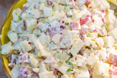 Büyük bir kâse kremalı, lezzetli kırmızı patates salatası.