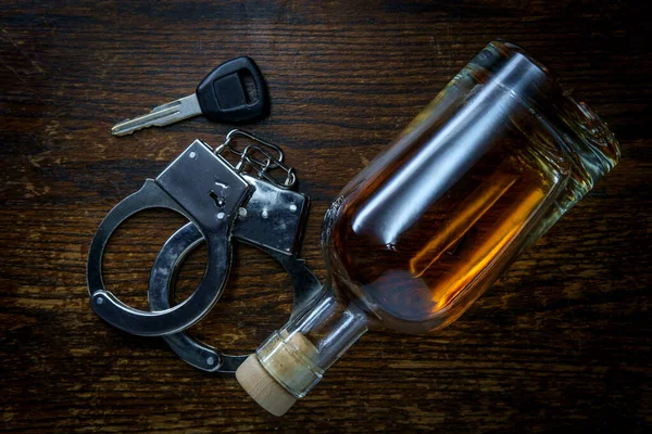 Полупустая Бутылка Виски Деревенском Деревянном Баре Ключами Наручниками Символизирующими Арест — стоковое фото