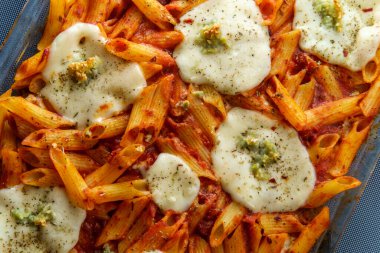 Fırında makarna makarna güveci üzerine de mozzarella ve İtalyan baharatı.