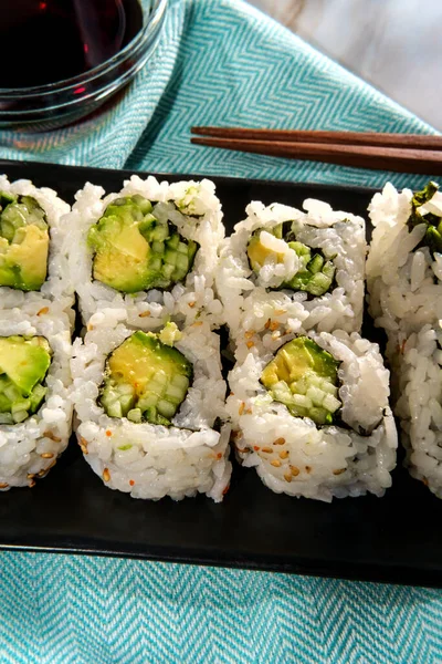 天気の良い日に屋外で食べる日本の野菜アボカドキュウリ寿司ワサビと醤油ロール — ストック写真