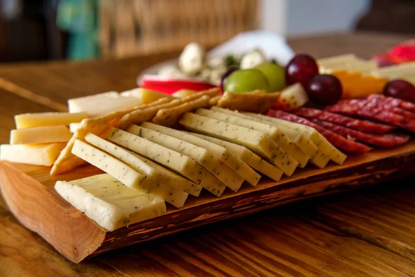 크래커 치즈와 살라미를 특징으로 이탈리아의 보드와 나무껍질 가장자리를 널빤지 위에서 — 스톡 사진