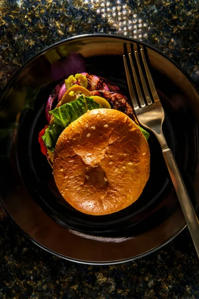 American food cheeseburger with pickled jalapeno peppers lettuce and grilled red onions