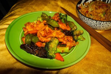 Çin sarımsaklı tavuk sotelenmiş sebze ve yanında kızarmış domuz pirinci.