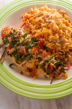 Stuffed cajun hasselback chicken with spicy pepper jack cheese and side of Spanish pigeon pea rice clipart