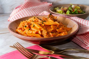 İtalyan penne alla vodka pembe krema sosu dilimlenmiş sosis ve salata