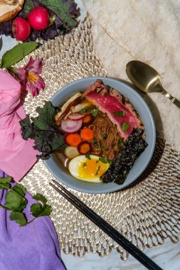 Kaynamış yumurta, yosun şeritleri turp ve dilimlenmiş havuçla süslenmiş kurutulmuş pembe ahi ton balığı.