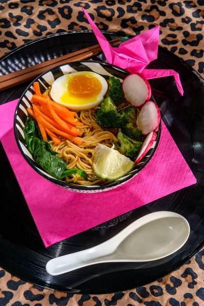 辣味的韩国蔬菜拉面 配上蔬菜和用餐巾纸叠成的折纸鹤的软蛋 — 图库照片