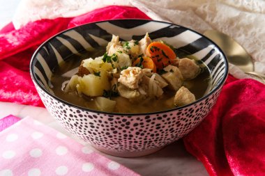 Zebra desenli kasede servis edilen tavuk ve pirinç çorbası.