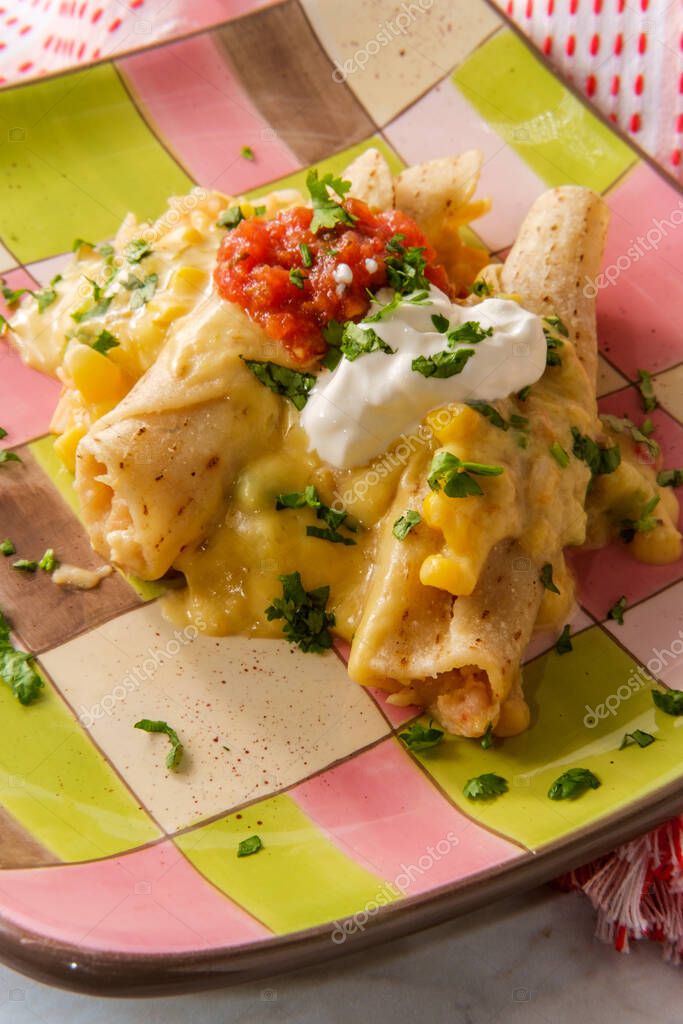 Enchiladas suizas con salsa bechamel cremosa y servidas sobre arroz