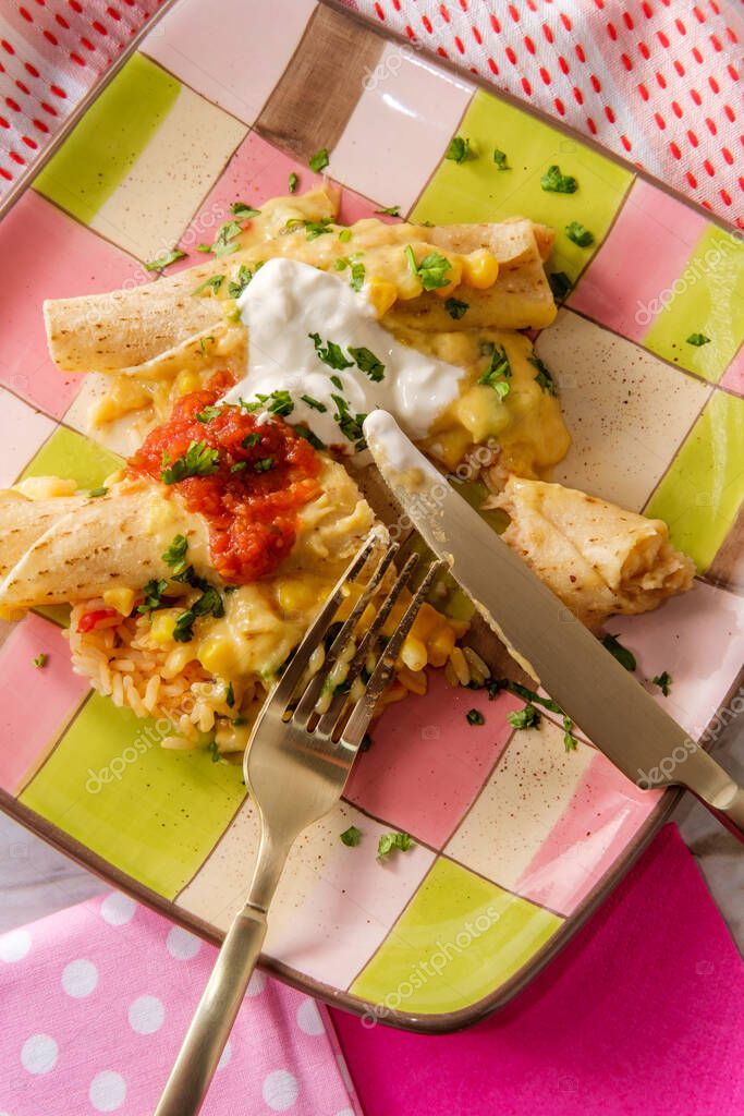 Enchiladas suizas con salsa bechamel cremosa y servidas sobre arroz
