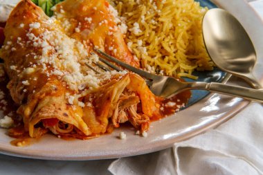 Geleneksel Meksika enchilada yemeği pilav ve yeniden kızartılmış fasulye ile servis edilir.