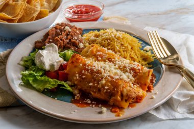 Geleneksel Meksika enchilada yemeği pilav ve yeniden kızartılmış fasulye ile servis edilir.