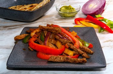 Meksika bifteği fajitası, kızarmış mısır tortilla ve guacamole.