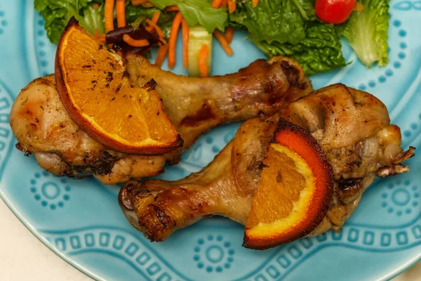 Kızarmış tavuk budu, portakal aromalı salata ve salata.